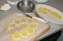 The disks are being put in layers into a buttered baking dish